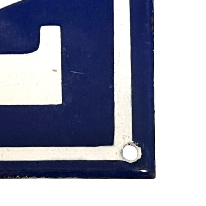 Corner of a blue and white sign with a metal grommet.