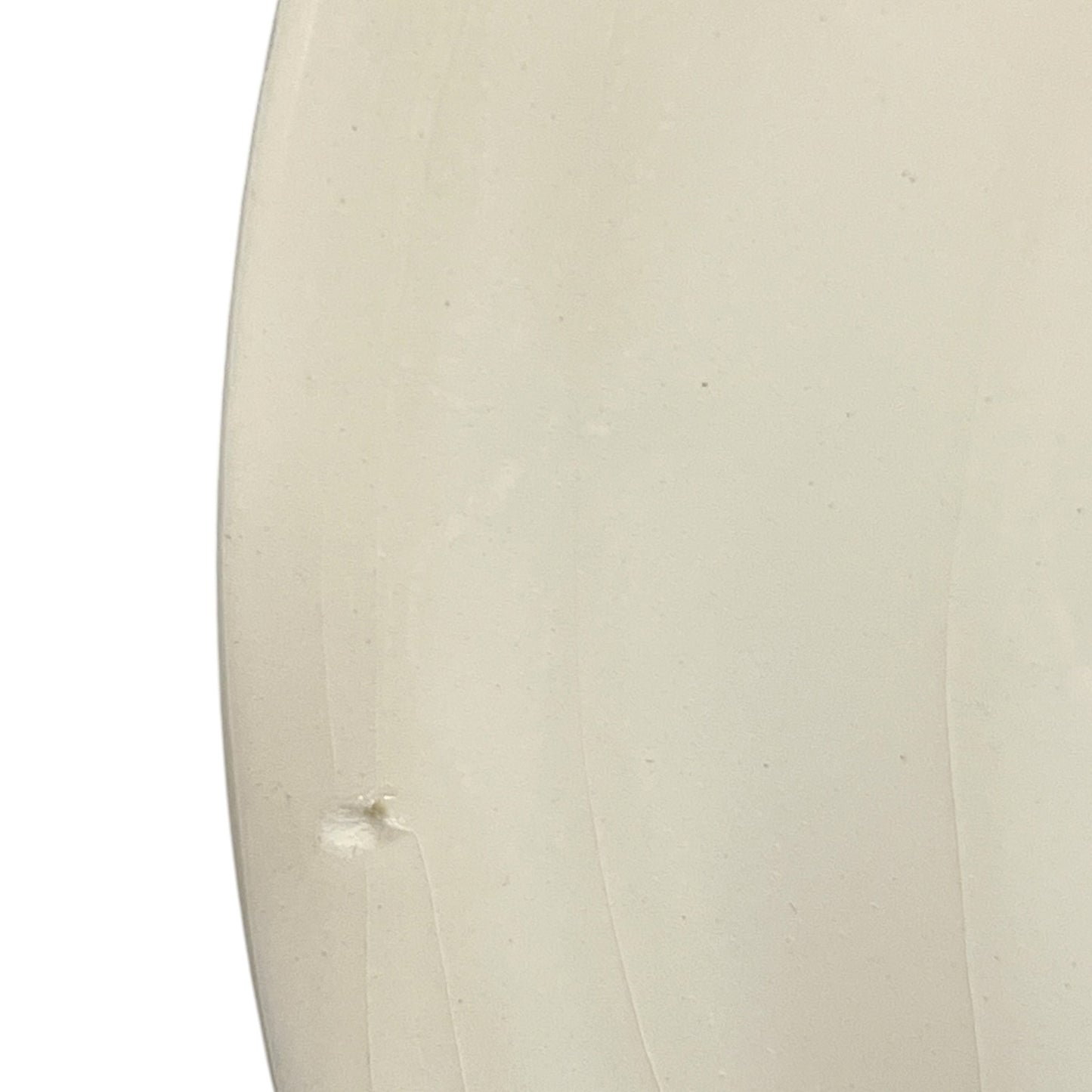 Close-up of a beige ceramic plate with a textured surface on a white background