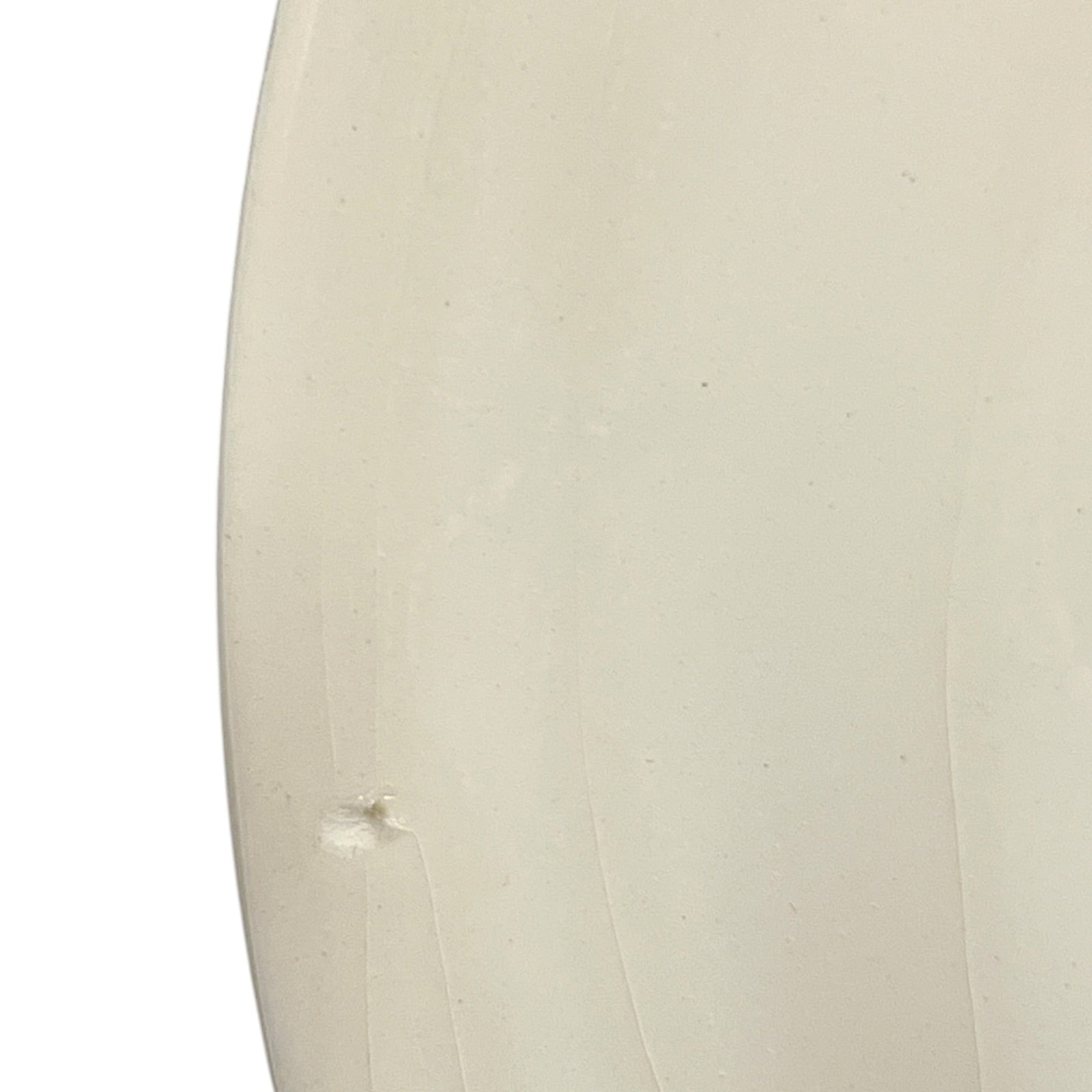 Close-up of a beige ceramic plate with a textured surface on a white background
