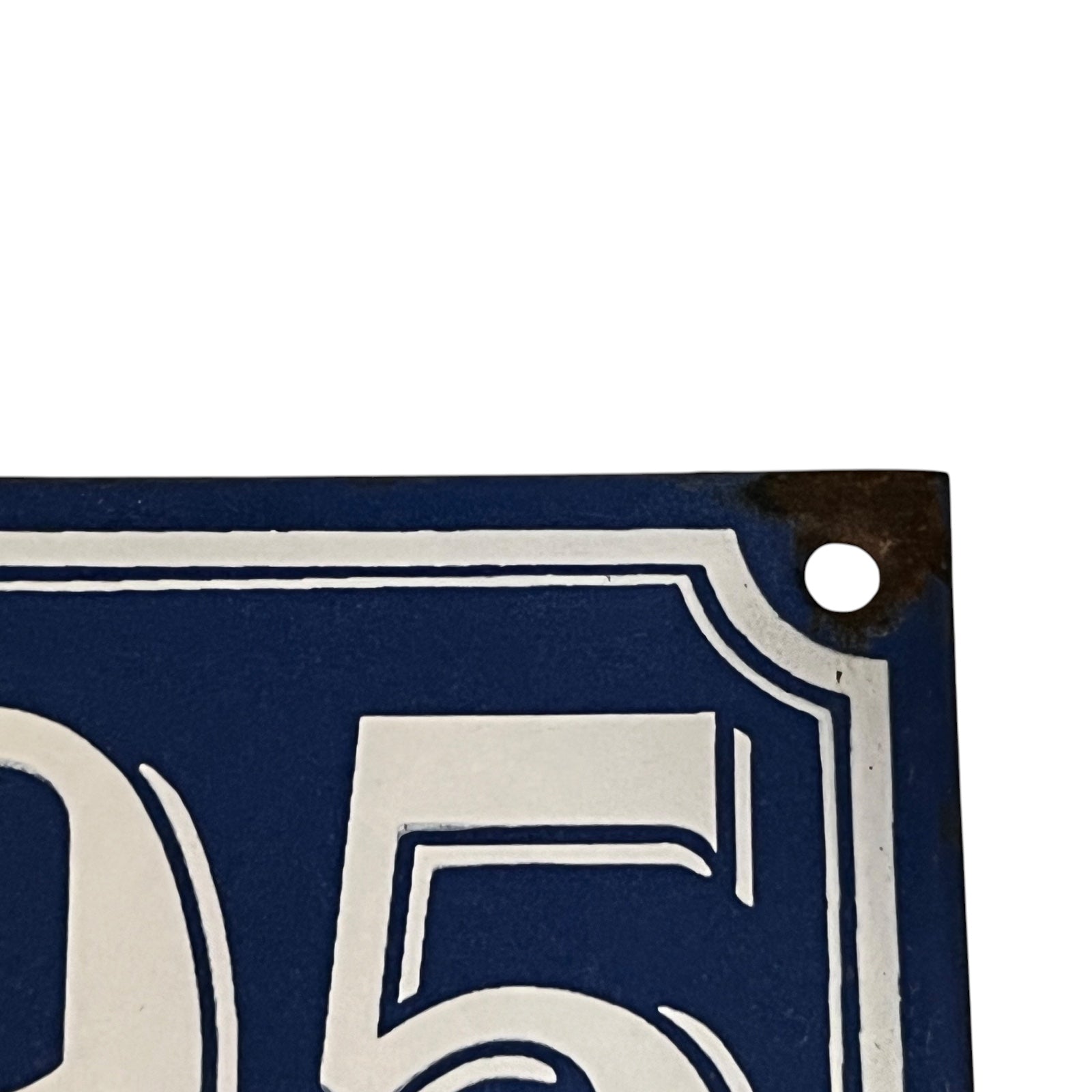 Close-up of a blue and white number 5 sign with a metal ring.