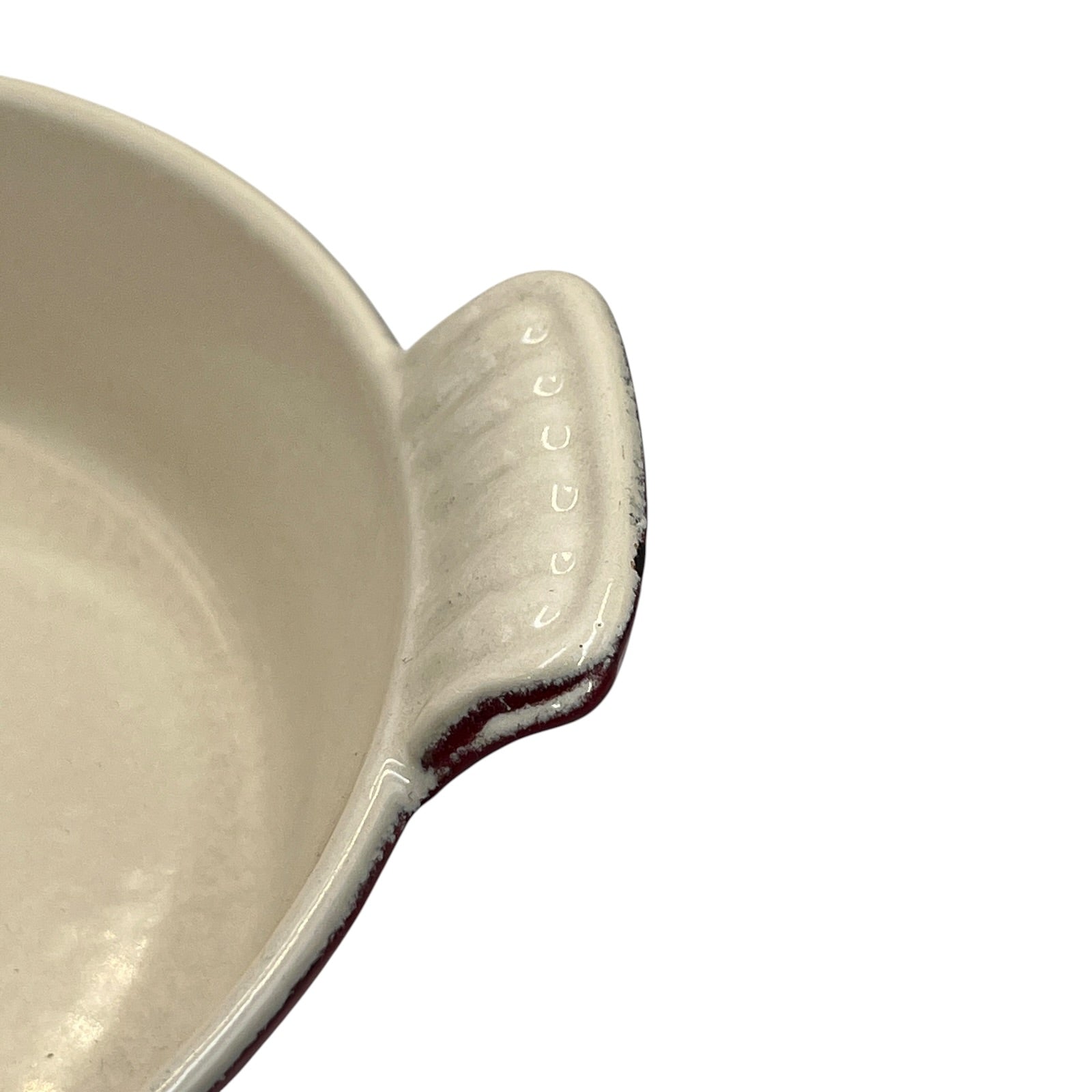 Close-up of a ceramic fish-shaped baking dish or casserole dish handle on a plain white background.