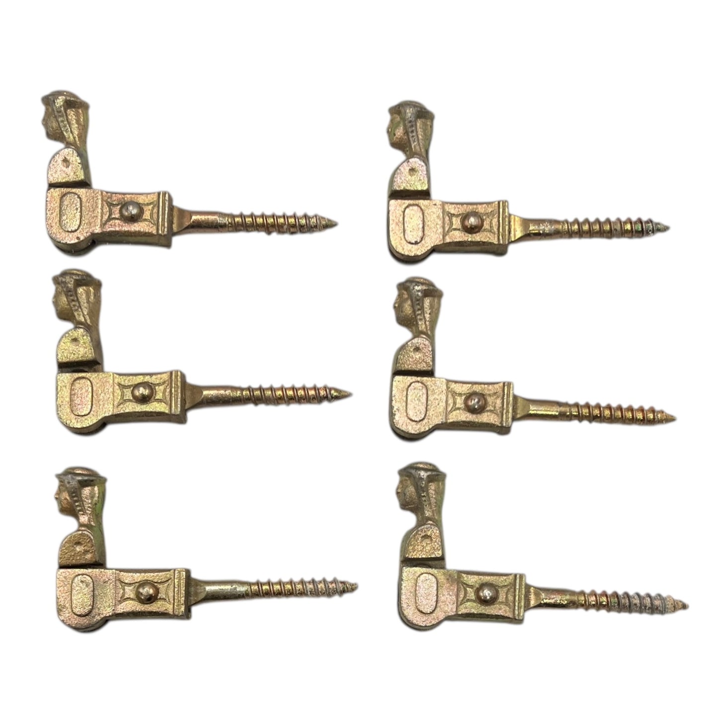 Six brass coloured French decorative shutter brackets on a white background