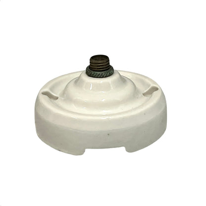 Small vintage French porcelain ceiling rose with a brass nut on a white background 