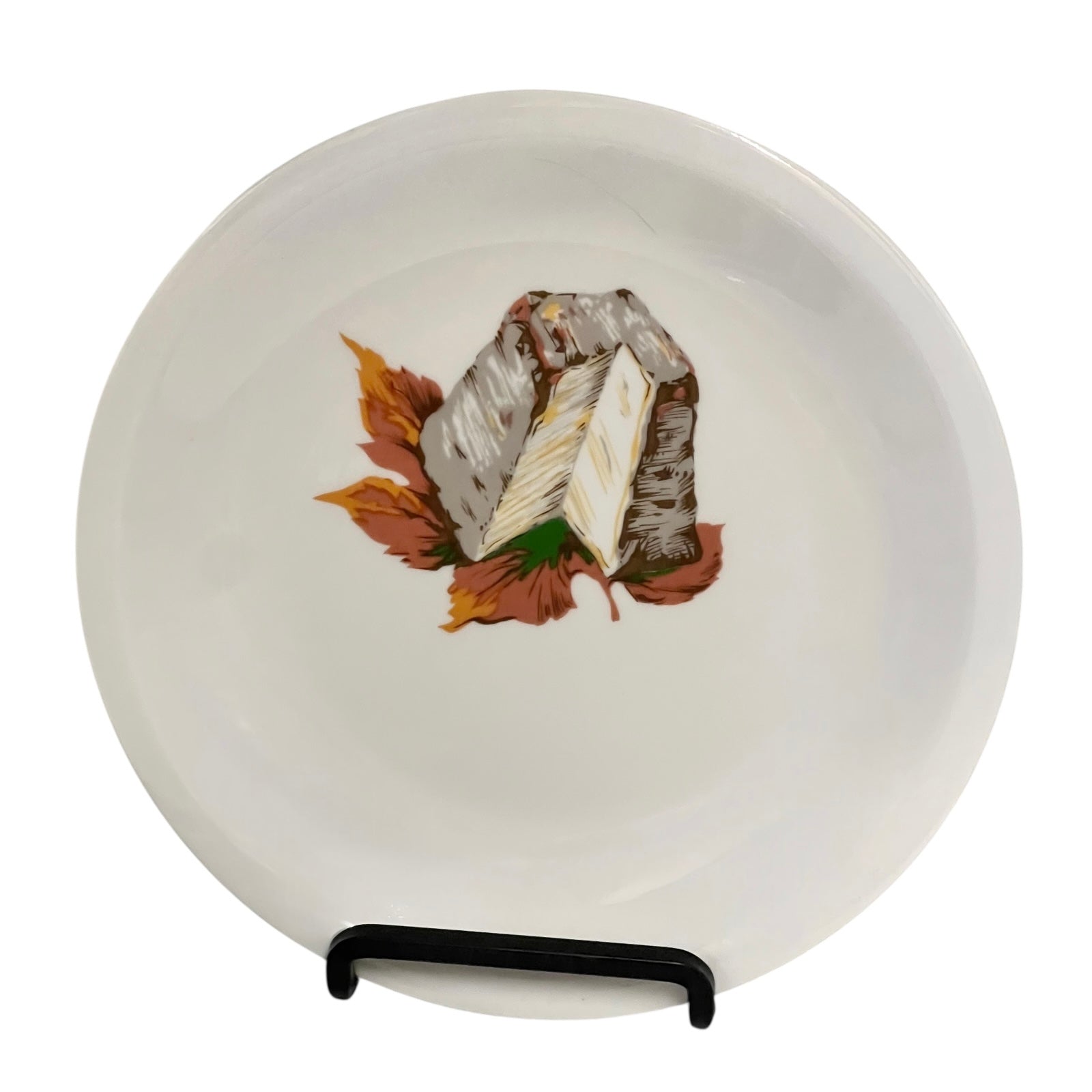 White plate with a cheese and leaf design on a stand