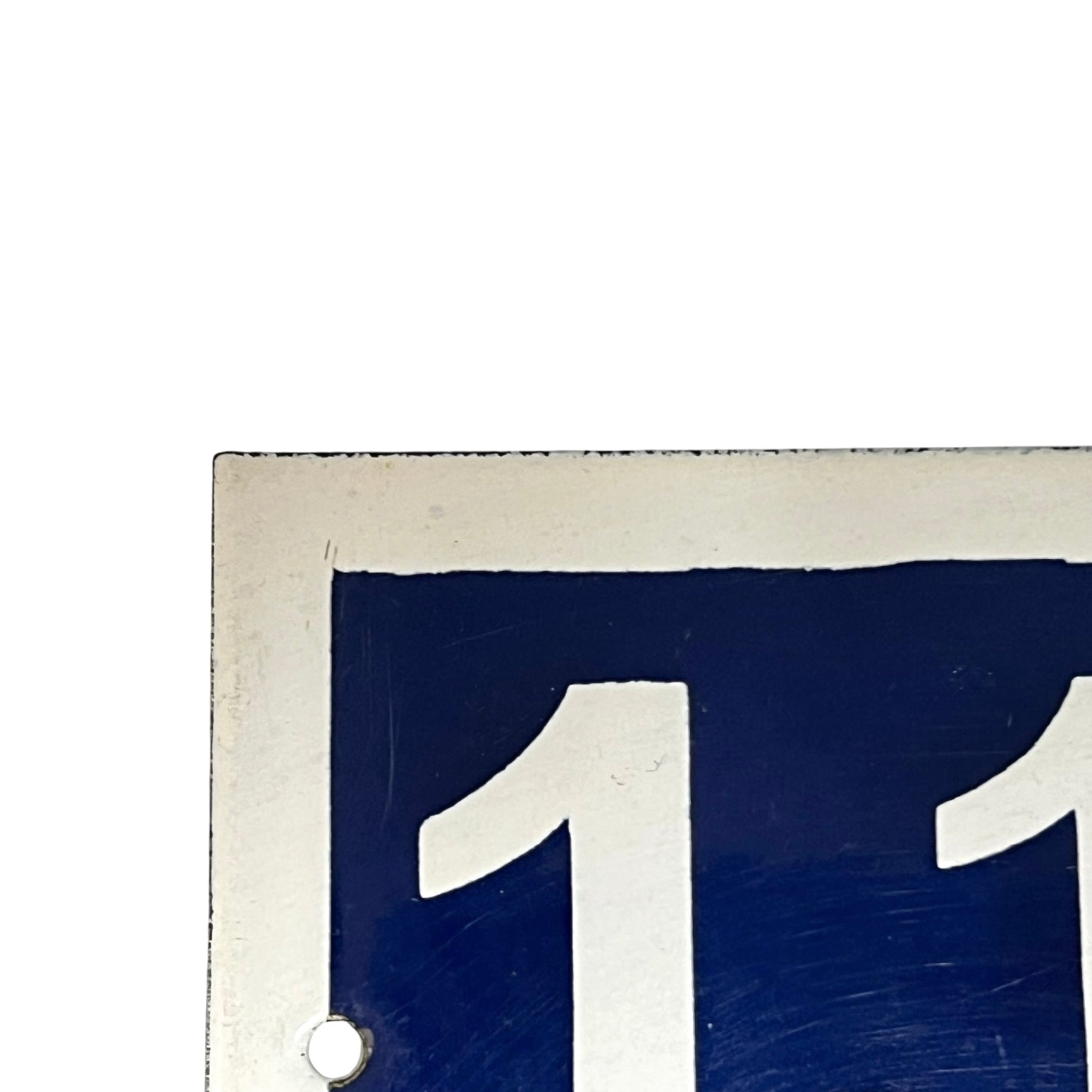 Close-up of a blue sign with white number 118 on a white background