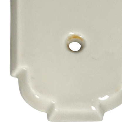 Close up of fingerplate with vintage car illustrations on a white background