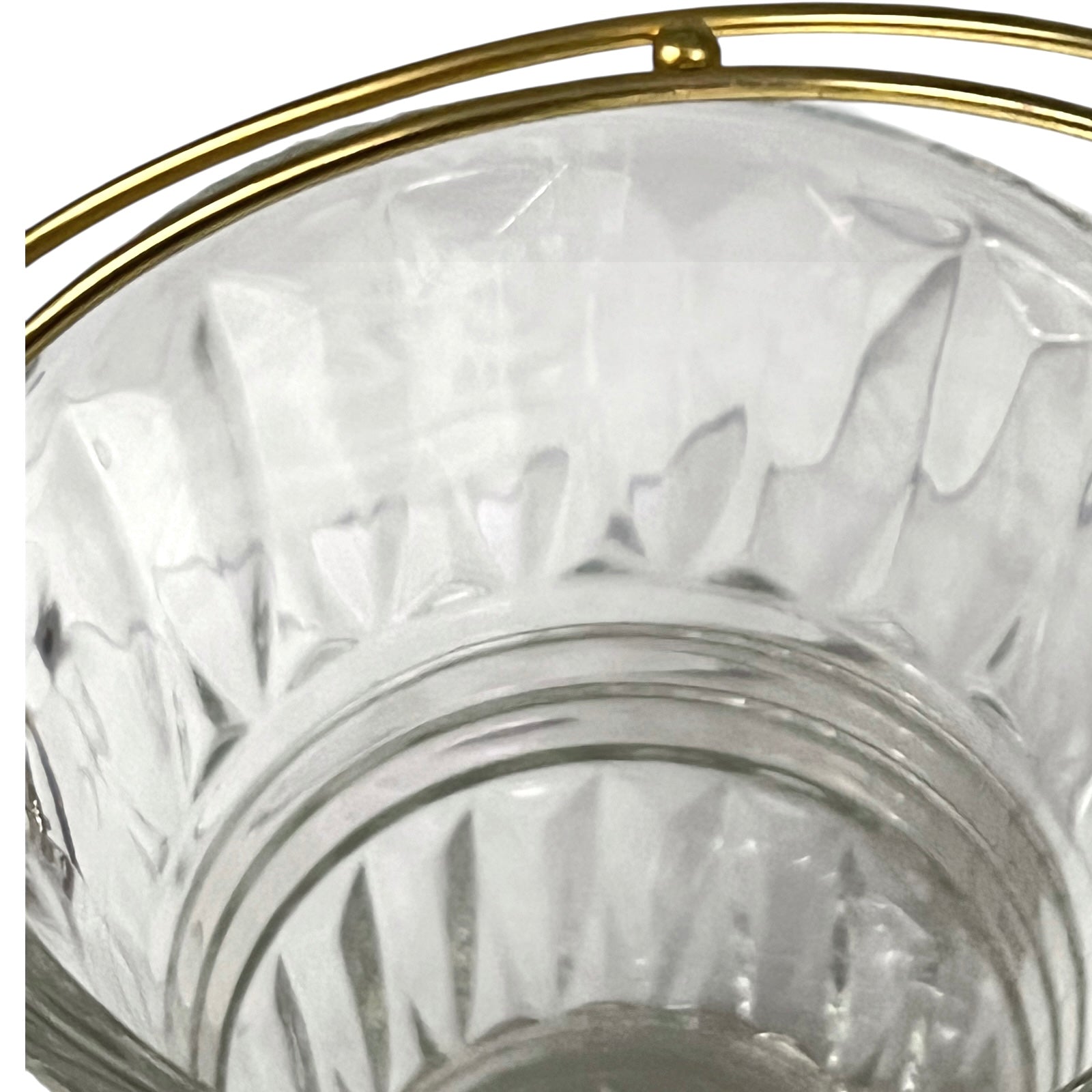 Clear glass candle holder with gold rim on a white background