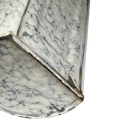 A close-up of a white marble-patterned metal irrigator or decorative container with dark veining and weathered edges, shown against a plain white background.