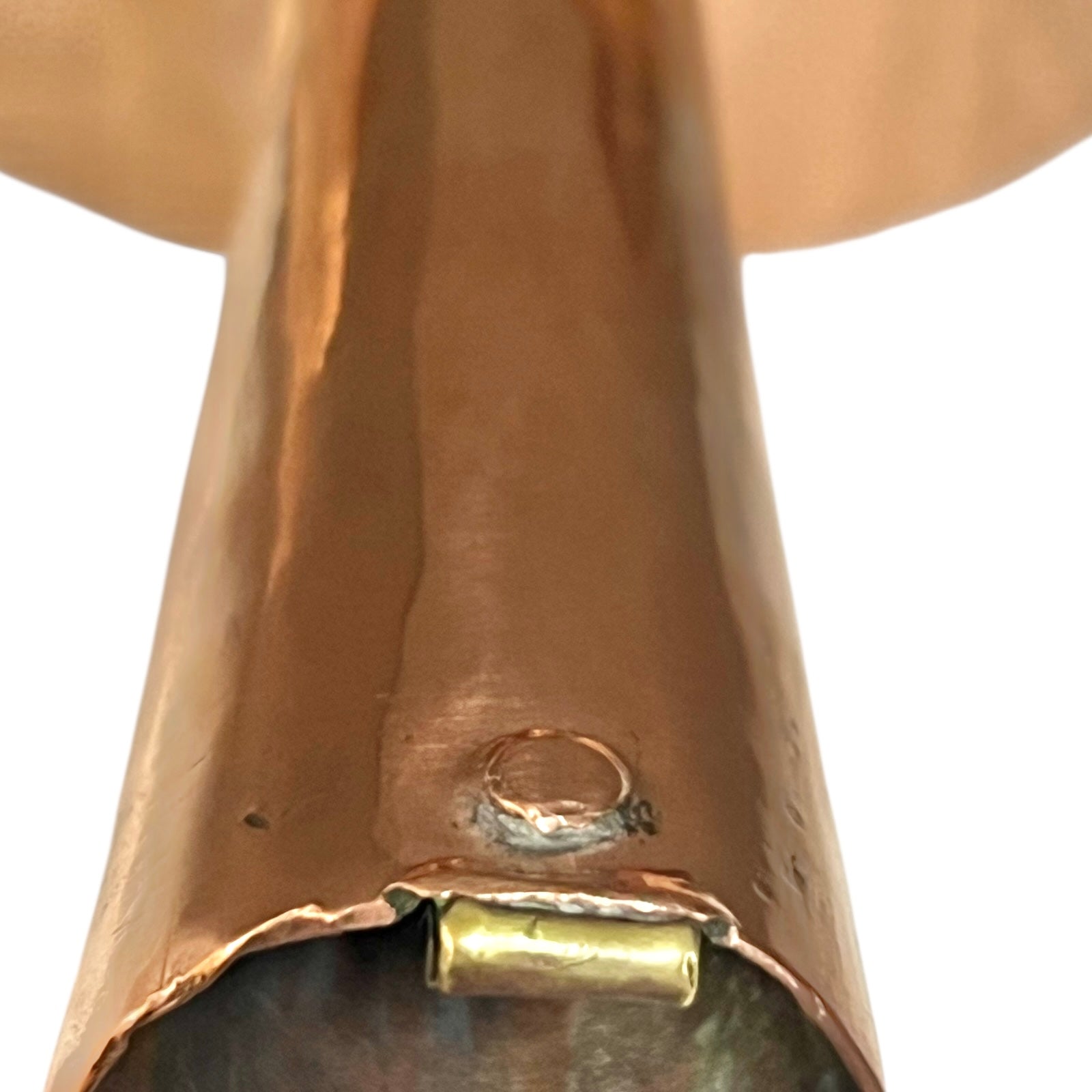 Close-up of a copper pot with a pouring spout on a white background