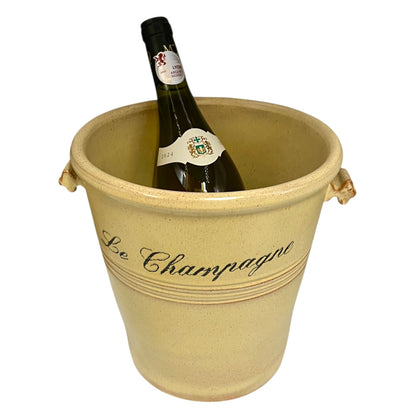 Wine bottle in a decorative beige bucket labeled 'Le Champagne' on a white background