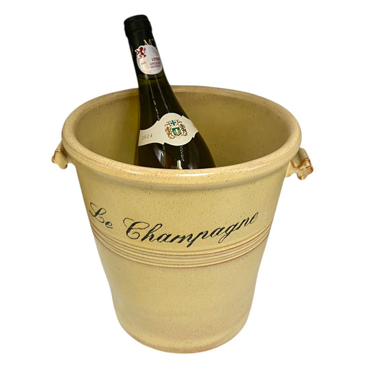 Wine bottle in a decorative beige bucket labeled 'Le Champagne' on a white background