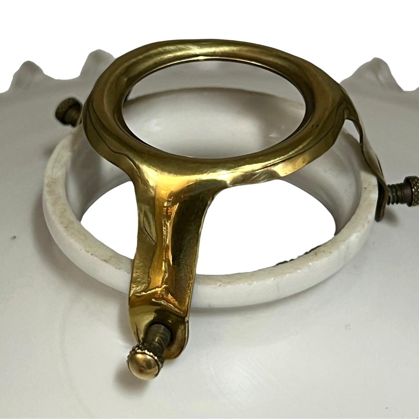 A vintage brass ceiling light fixture ring with a white porcelain or ceramic collar and visible mounting screws, shown on a white background.