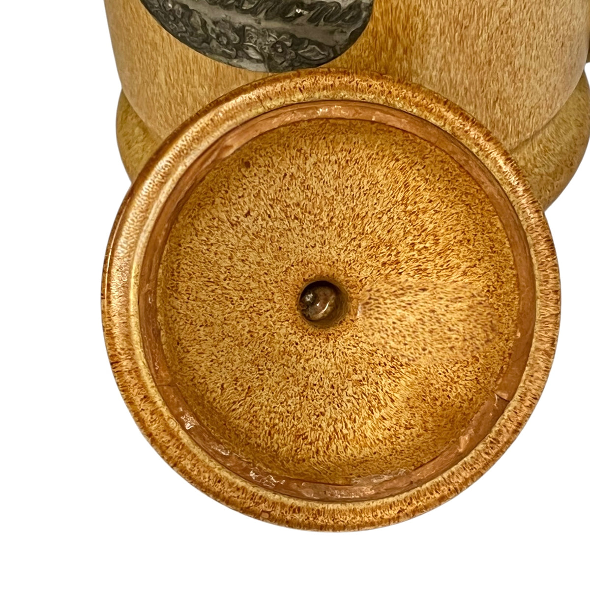 Close-up of a round, textured gold-toned metal container or vessel with a small central screw opening, shown against a plain white background.