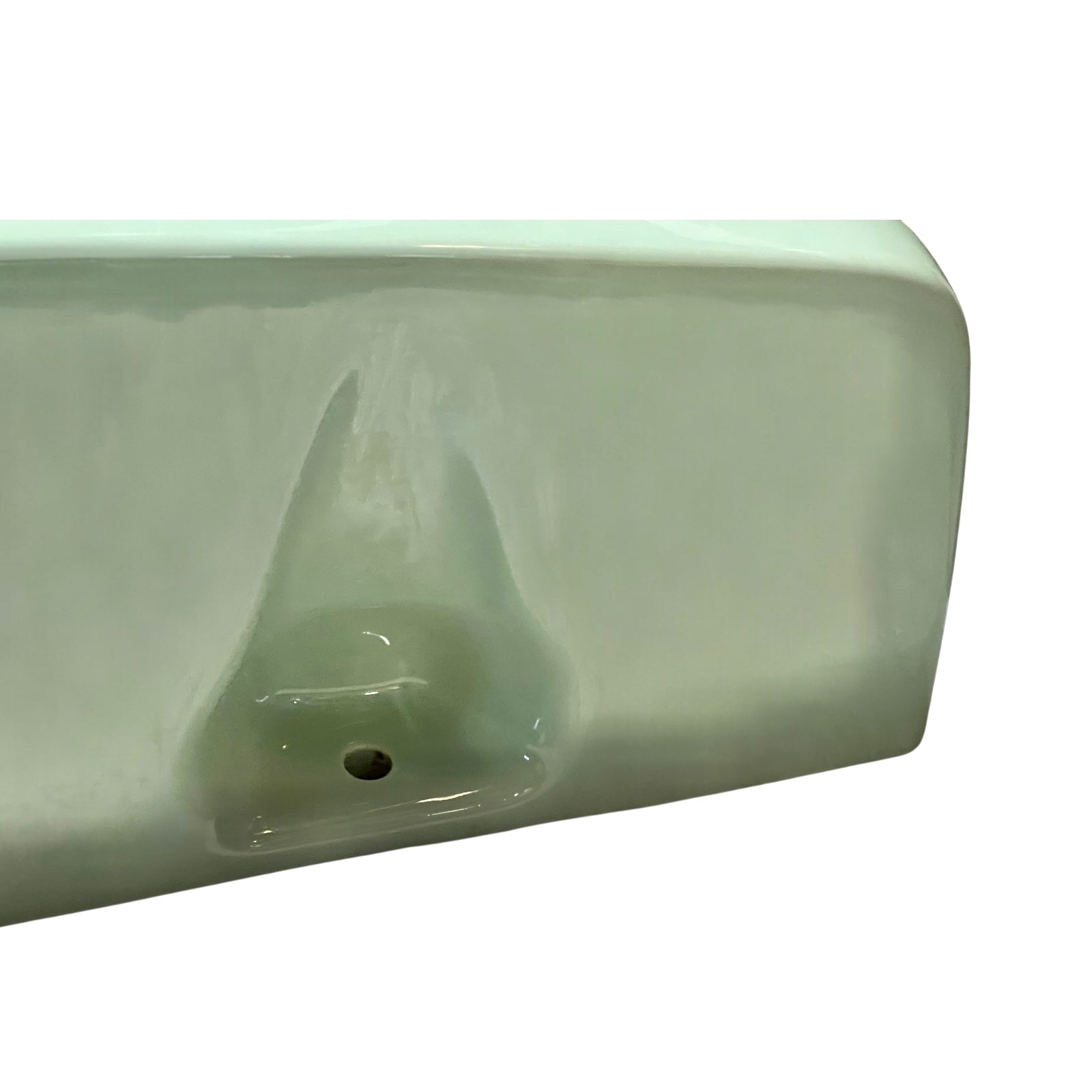 close up of pale green ceramic shelf on a white background