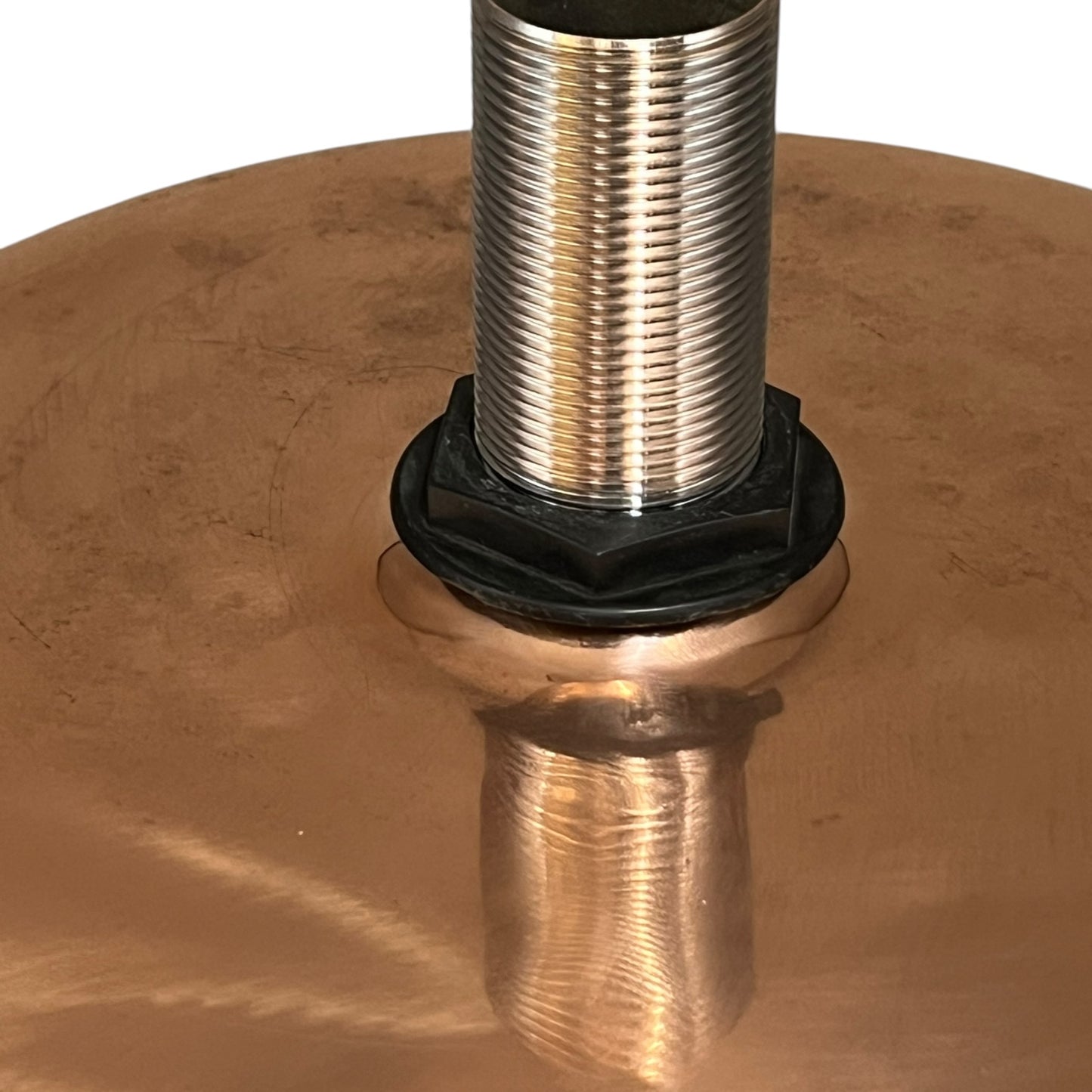 Close-up of a copper sink with a drain plug on a white background
