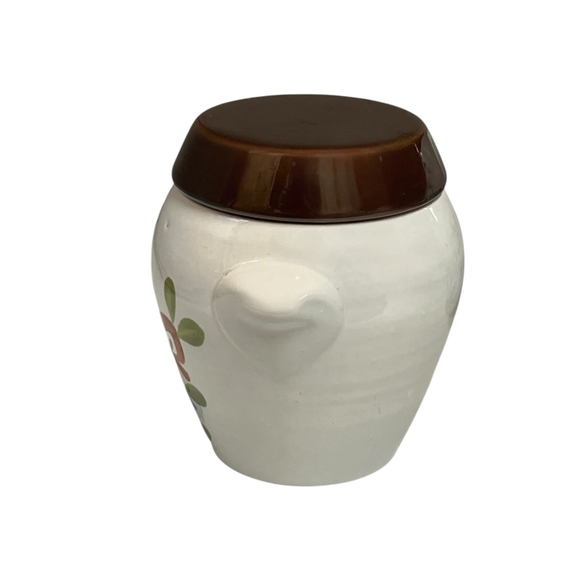 A small ceramic jar with a rounded white body, a brown lid, and a partial floral decoration on the side, shown against a plain white background.