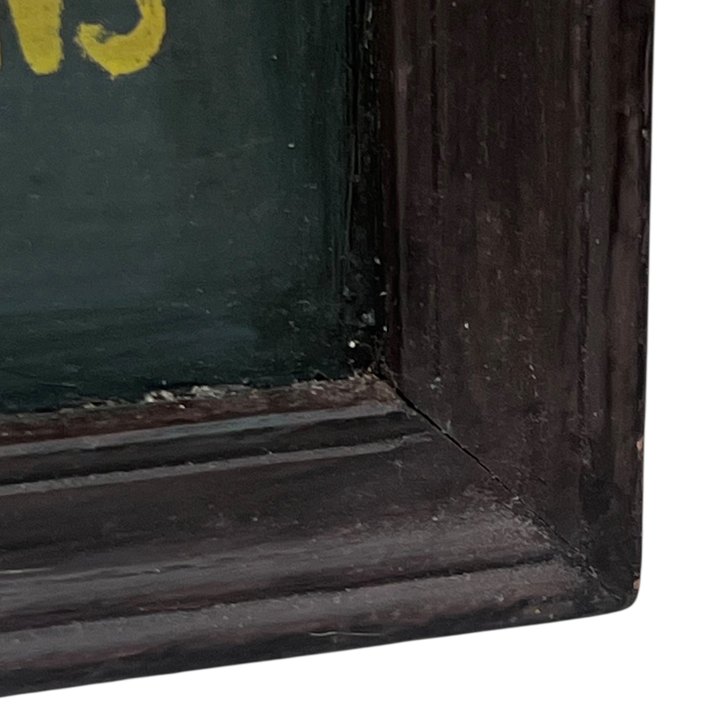 Corner of a framed picture with a dark brown frame and green interior.