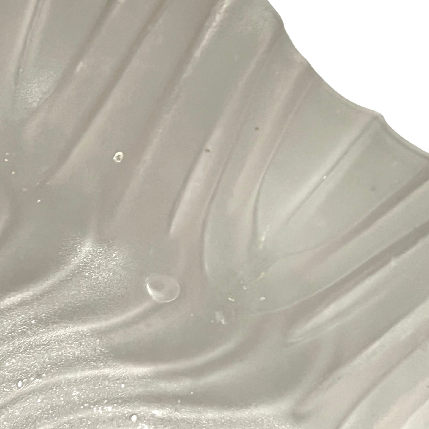 Close up of a glass lampshade and brass fittings on a white background