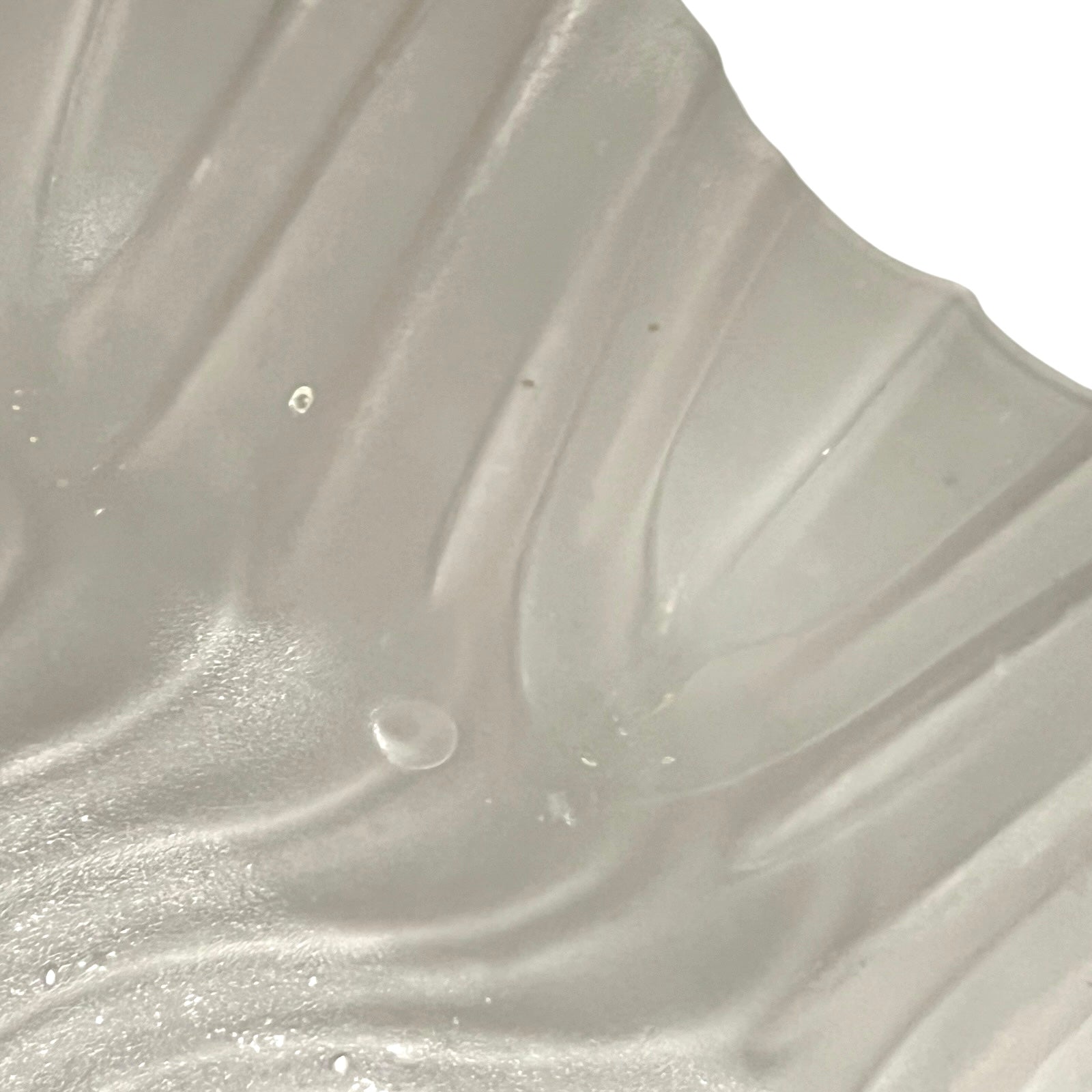 Close up of a glass lampshade and brass fittings on a white background