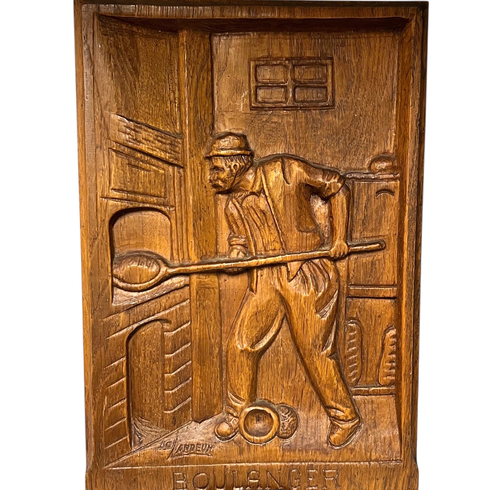 Wooden plaque with a carved scene of a man with a tool, likely a blacksmith, on a white background.