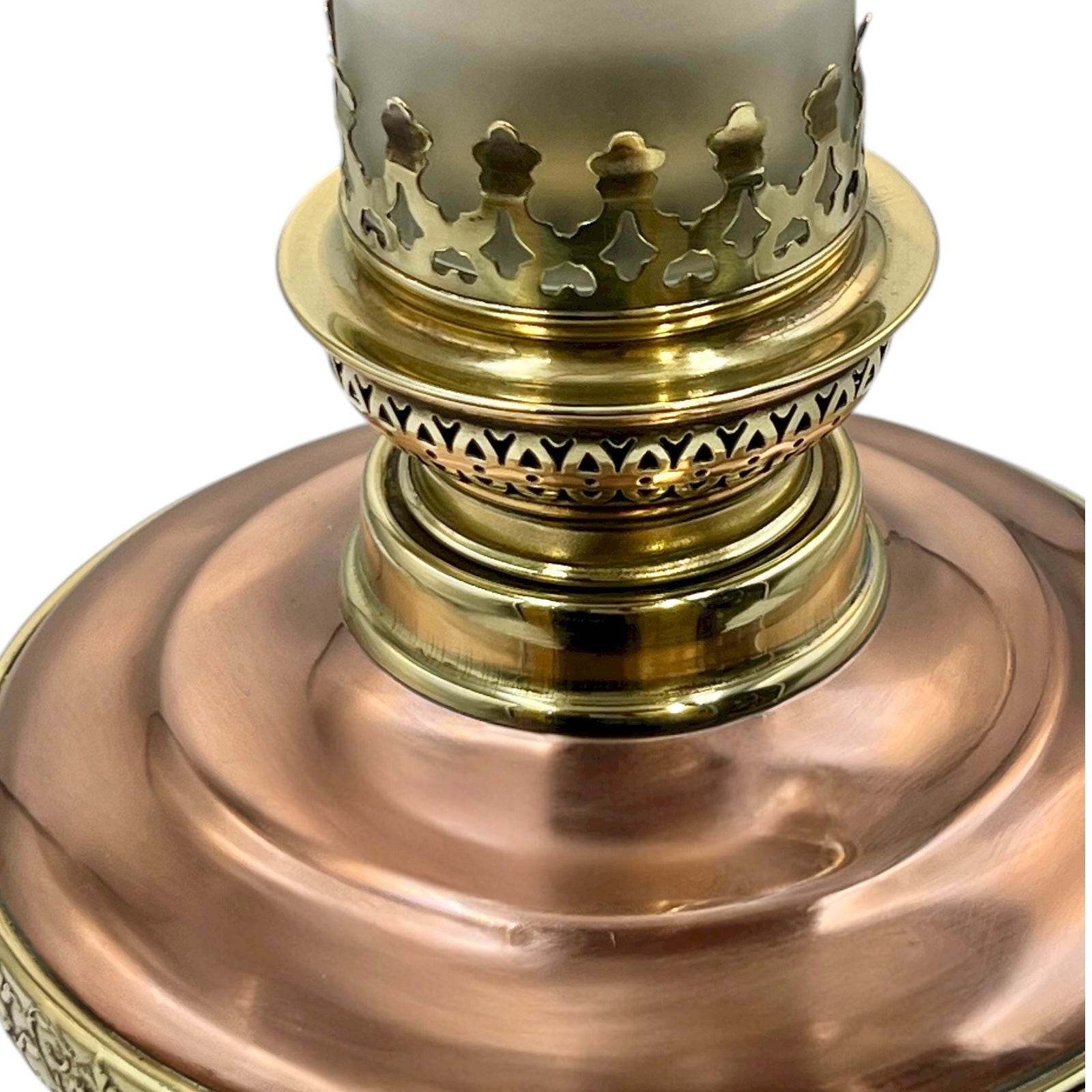 Close-up of a brass and copper lamp base with intricate designs on a white background