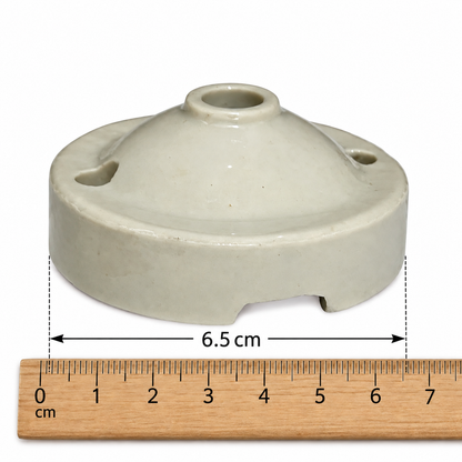 A small ceramic ceiling rose with a rounded, dome-shaped top and side holes, shown above a wooden ruler marked in centimetres to indicate its 6.5 cm width.