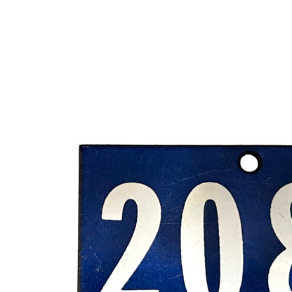 A close-up of a blue rectangular sign or plaque with large white numerals '208' and a small round hole near the top right, shown against a white background.