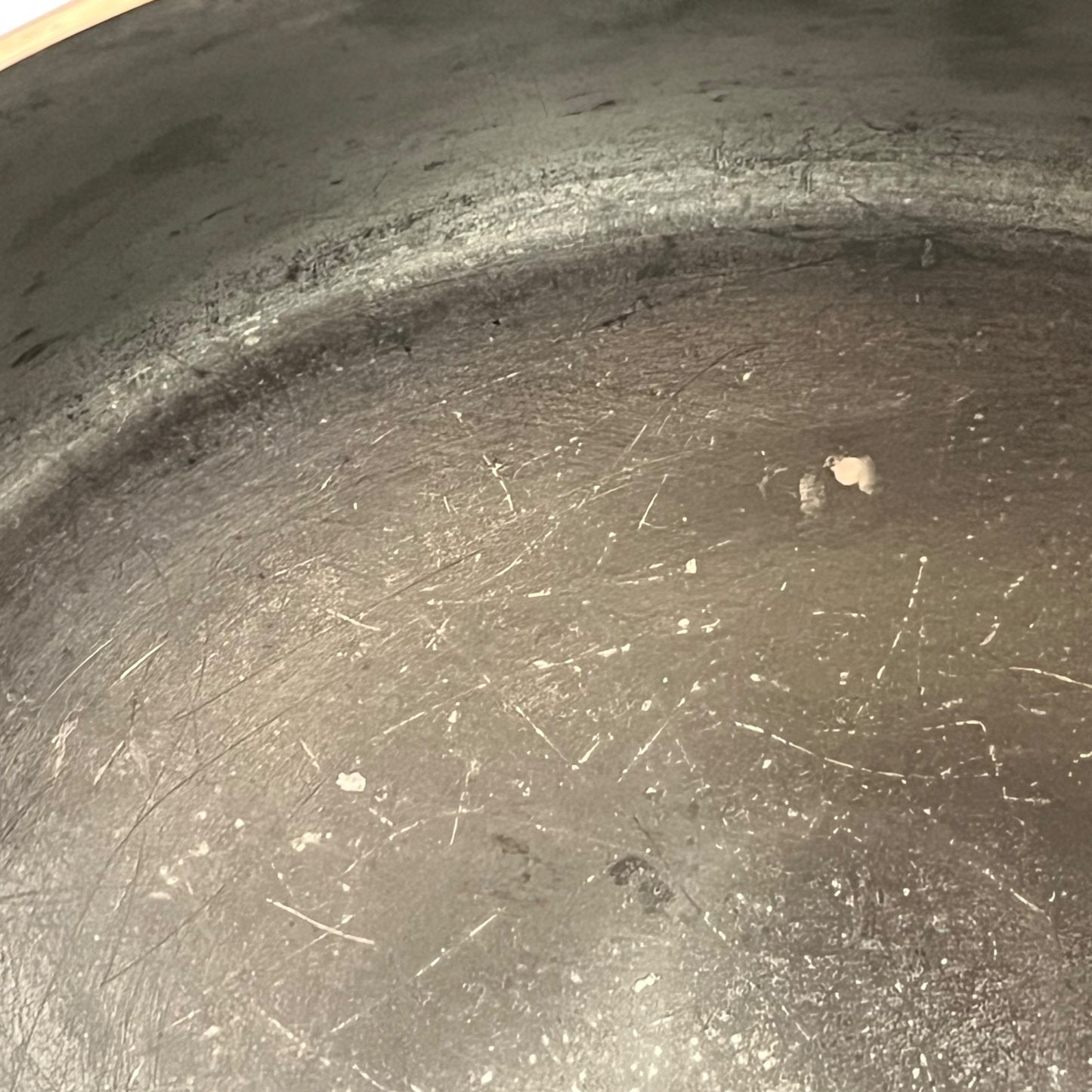Close up of the inside of a French copper pan with tin lining on a white background
