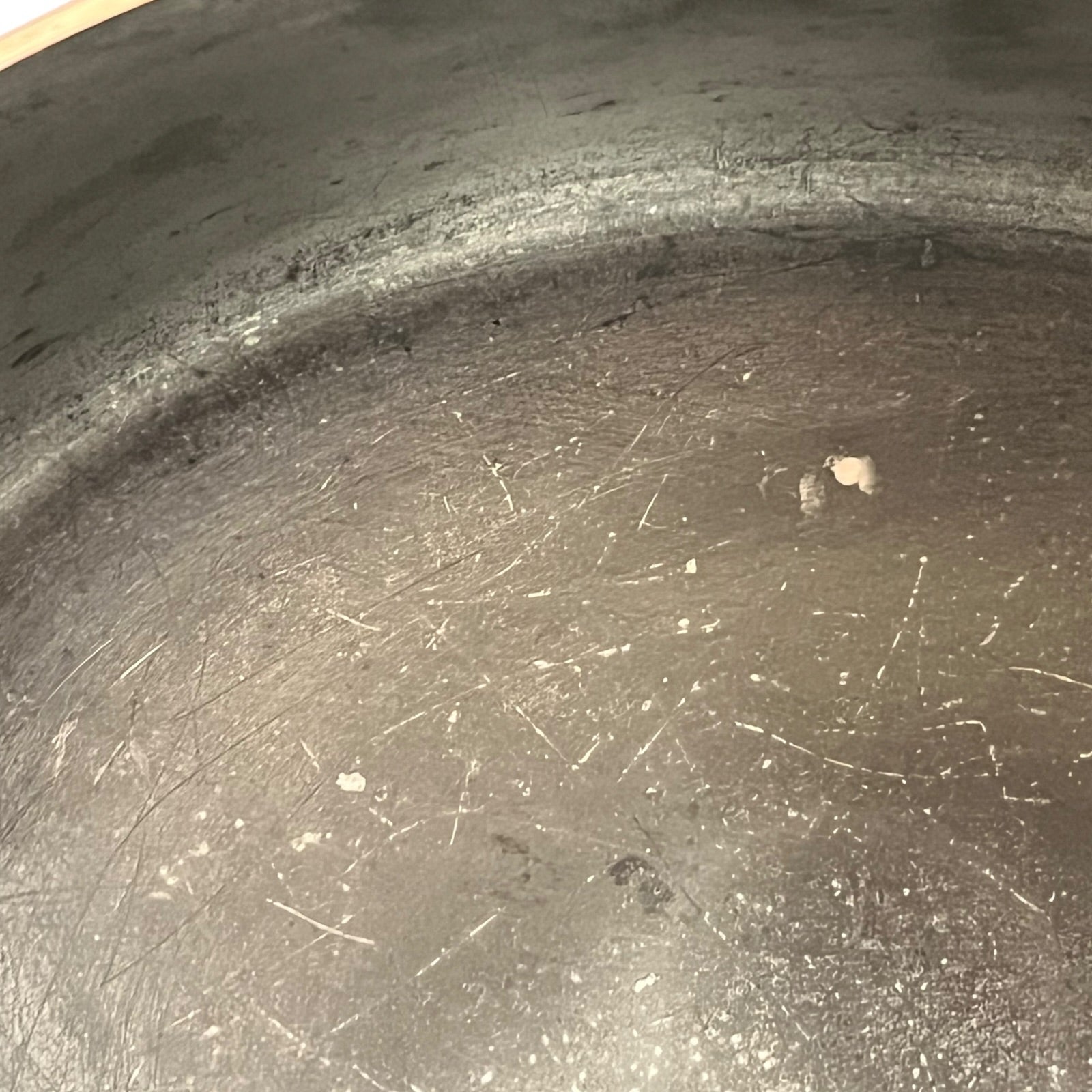 Close up of the inside of a French copper pan with tin lining on a white background