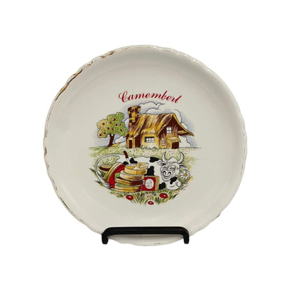Decorative plate with farm scene and 'Camembert' text on a white background