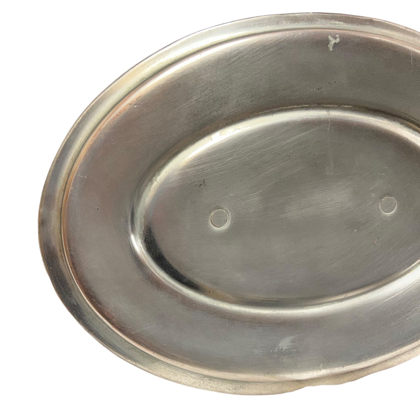 Close up of the inside of a French copper pan with tin lining on a white background