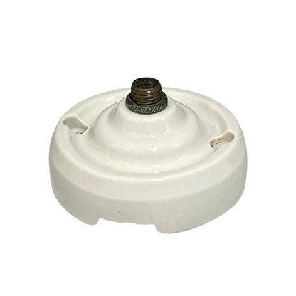 Small vintage French porcelain ceiling rose with a brass nut on a white background 