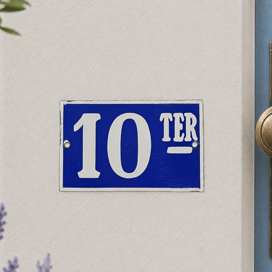 Blue house number sign with '10 TER' on a white wall.