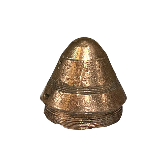 A small WW1 brass fuse paperweight with a textured finish on a white background 