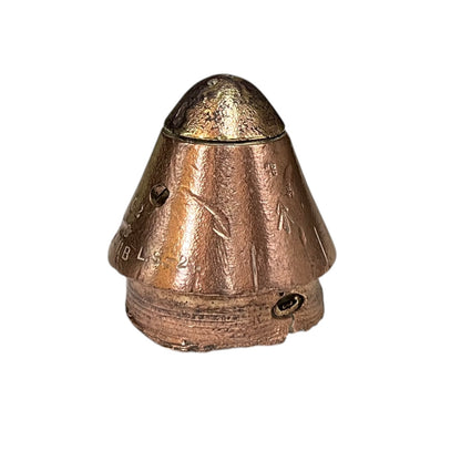 A small ww1 brass fuse with a conical top and cylindrical base, photographed against a plain white background