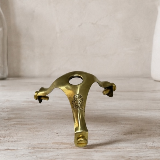 Brass pendant light holder gallery on a wooden surface with a neutral background