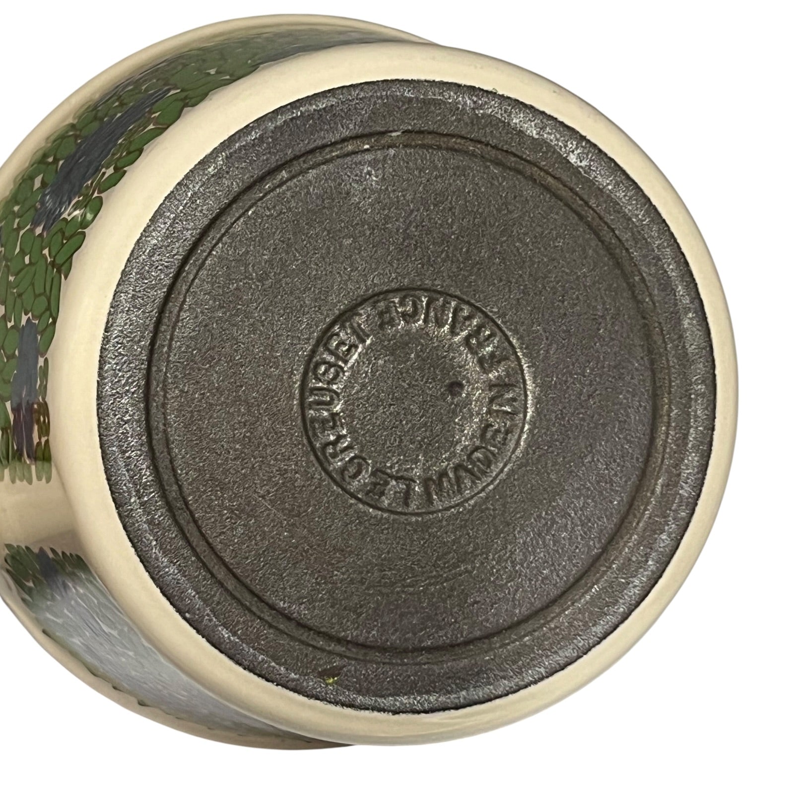 Base view of a le Creuset pan showing the makers mark on a white background 