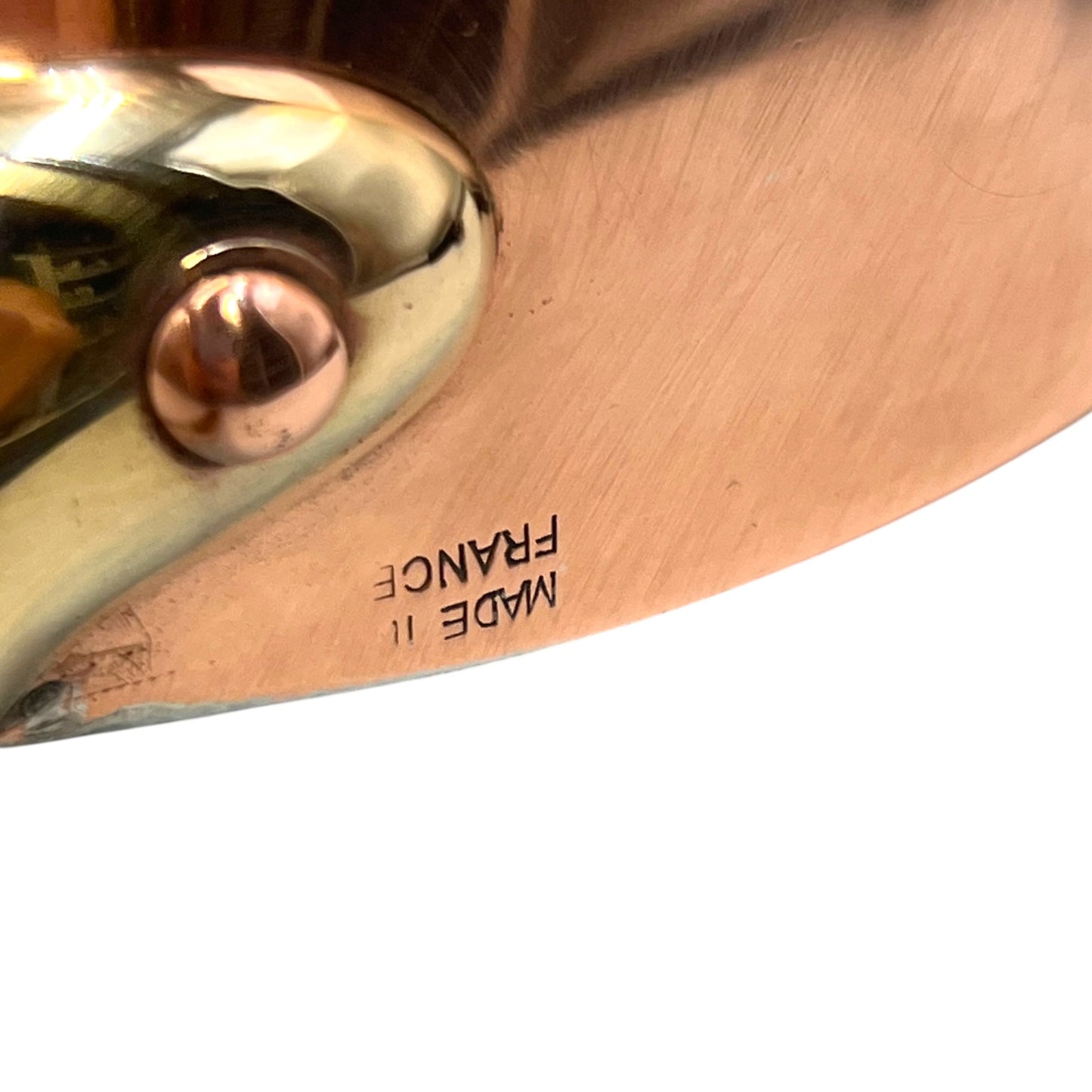 Small copper frying pan with a brass handle, Made in France stamp and tin lining on a white background
