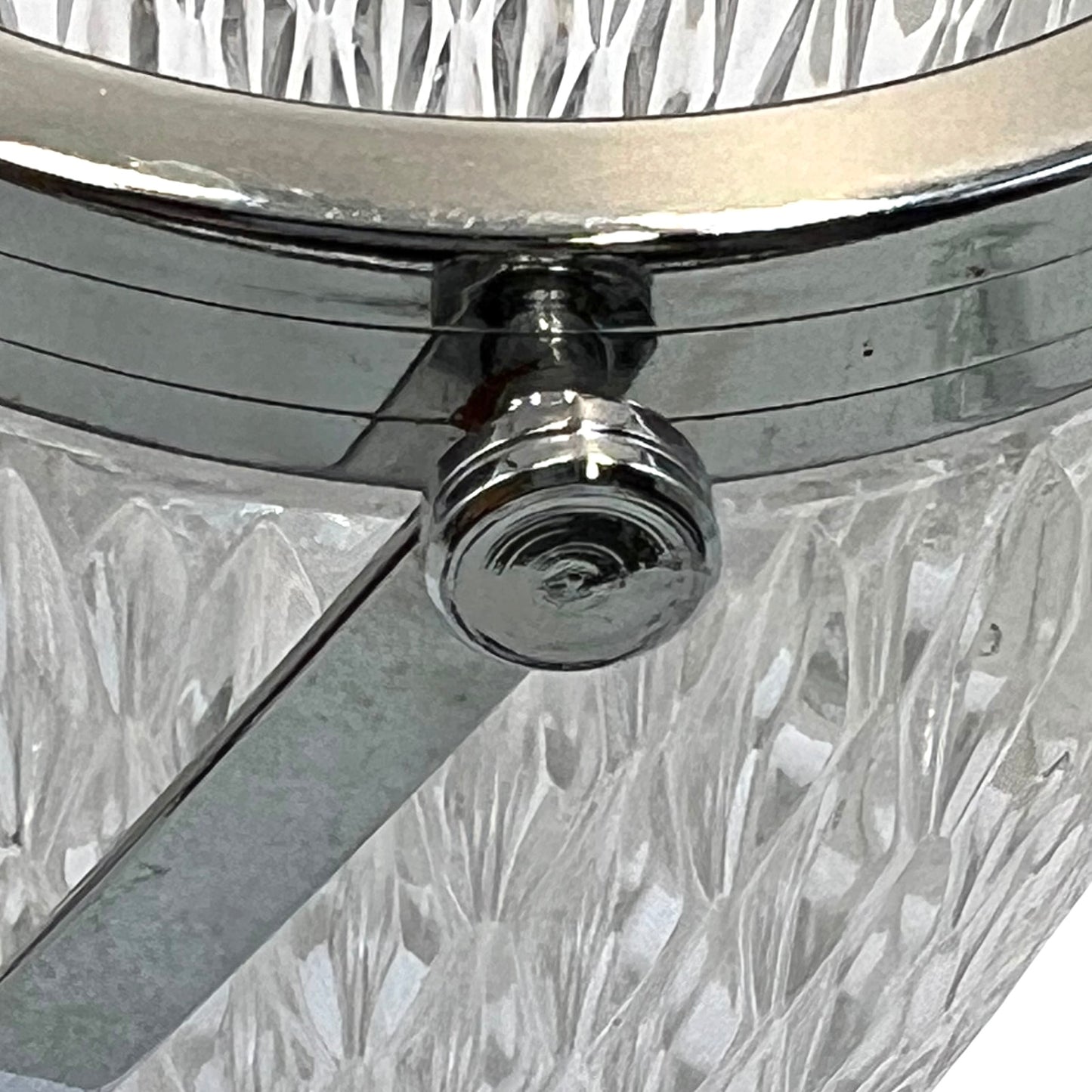 Close up of a French vintage glass ice bucket with a silver coloured collar and a handle on a white background 