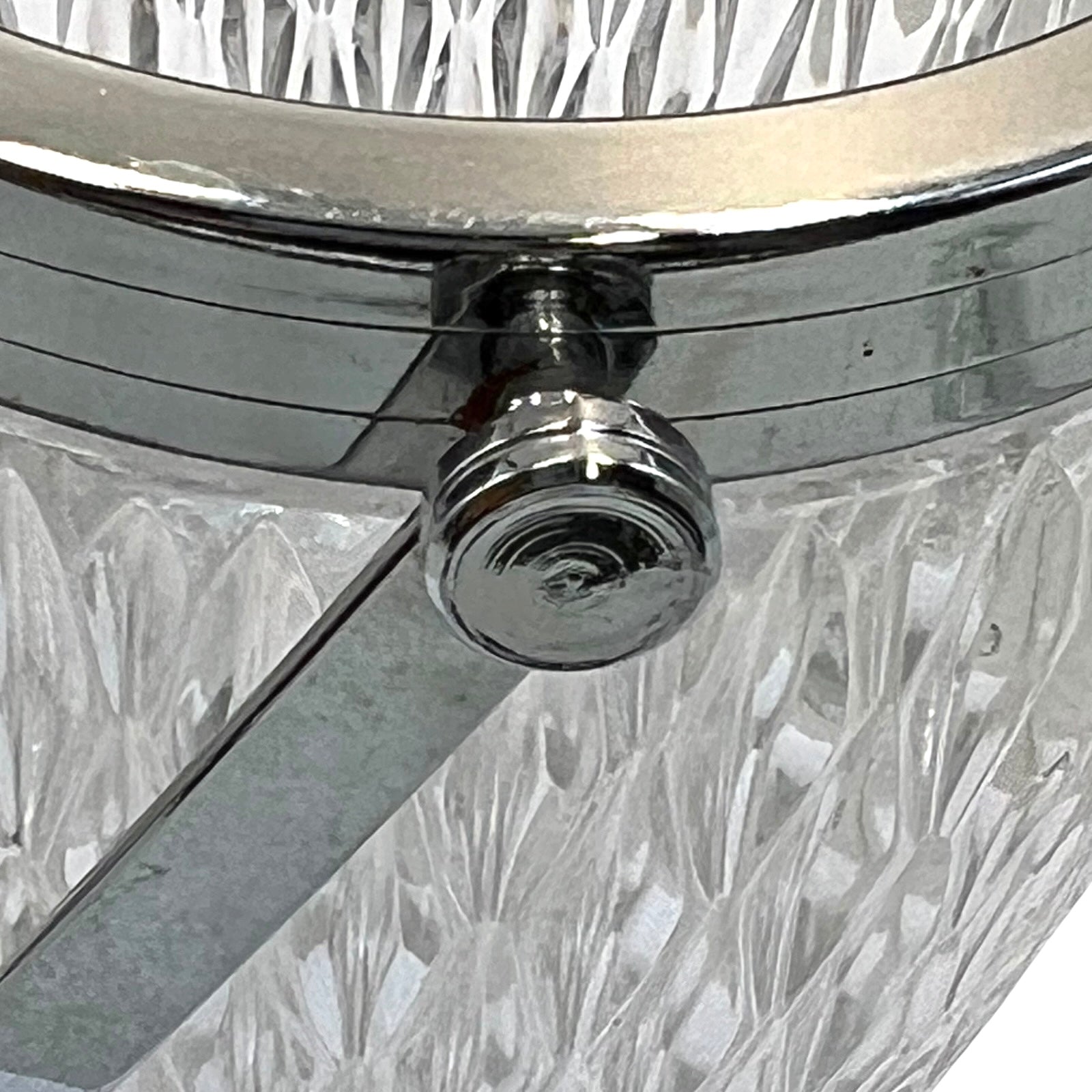 Close up of a French vintage glass ice bucket with a silver coloured collar and a handle on a white background 