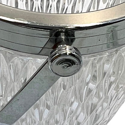 Close up of a French vintage glass ice bucket with a silver coloured collar and a handle on a white background 