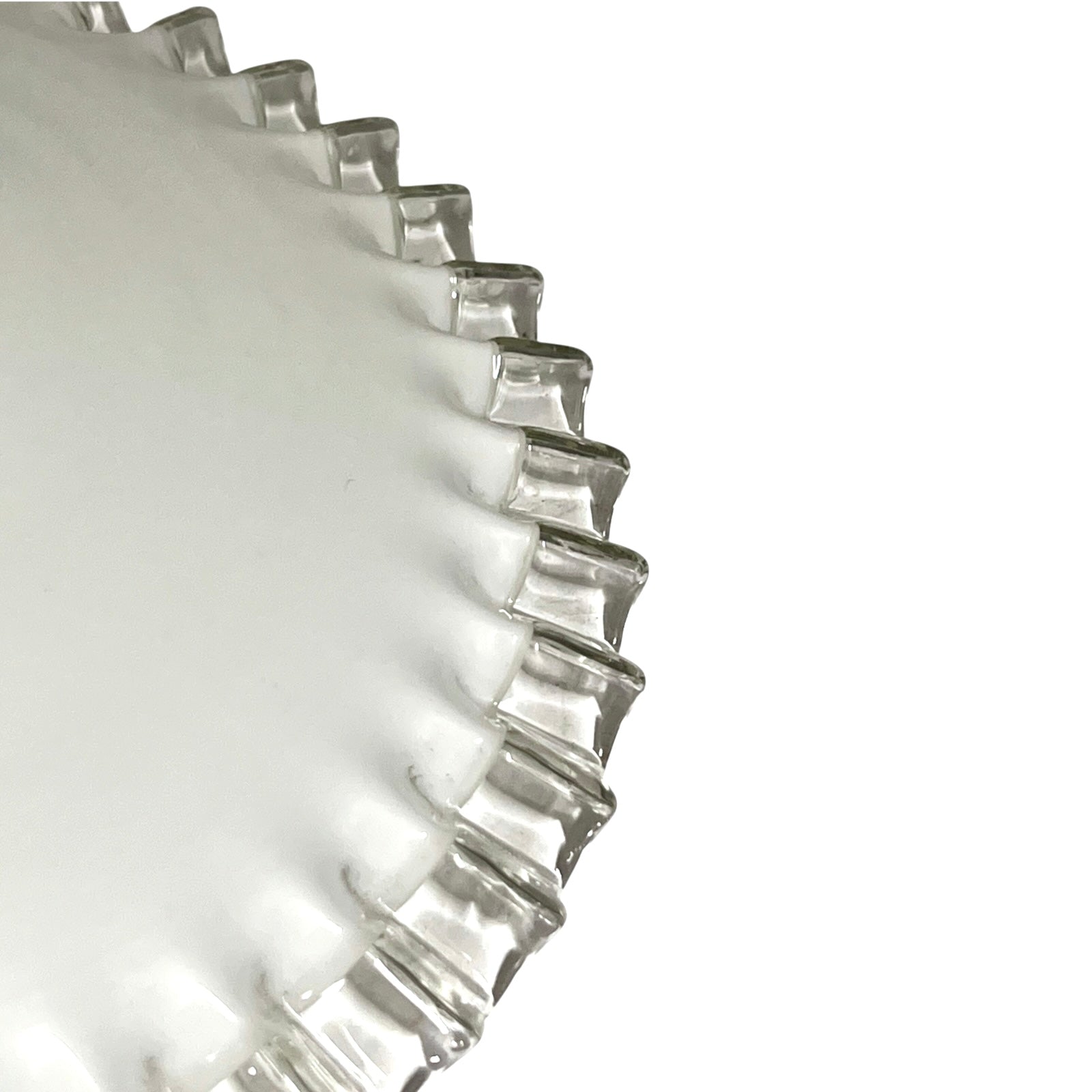Close-up of a clear glass lampshade with a fluted, scalloped rim on a plain white background.