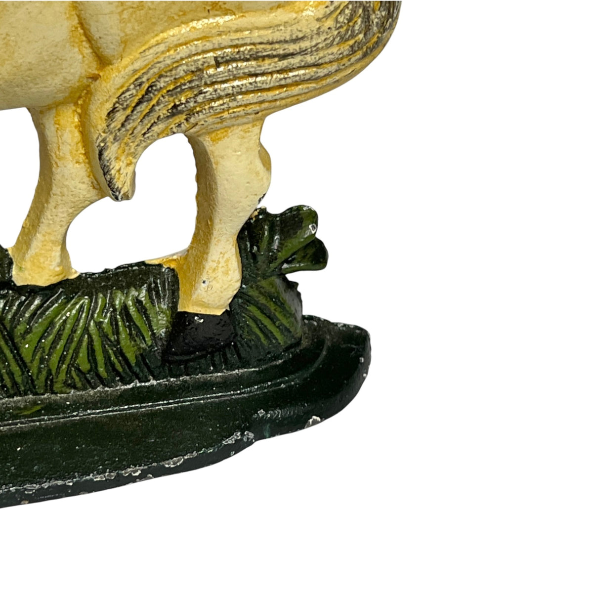 Close-up detail of a vintage hand-painted figurine showing the lower body of a horse standing on a dark green base with grass.