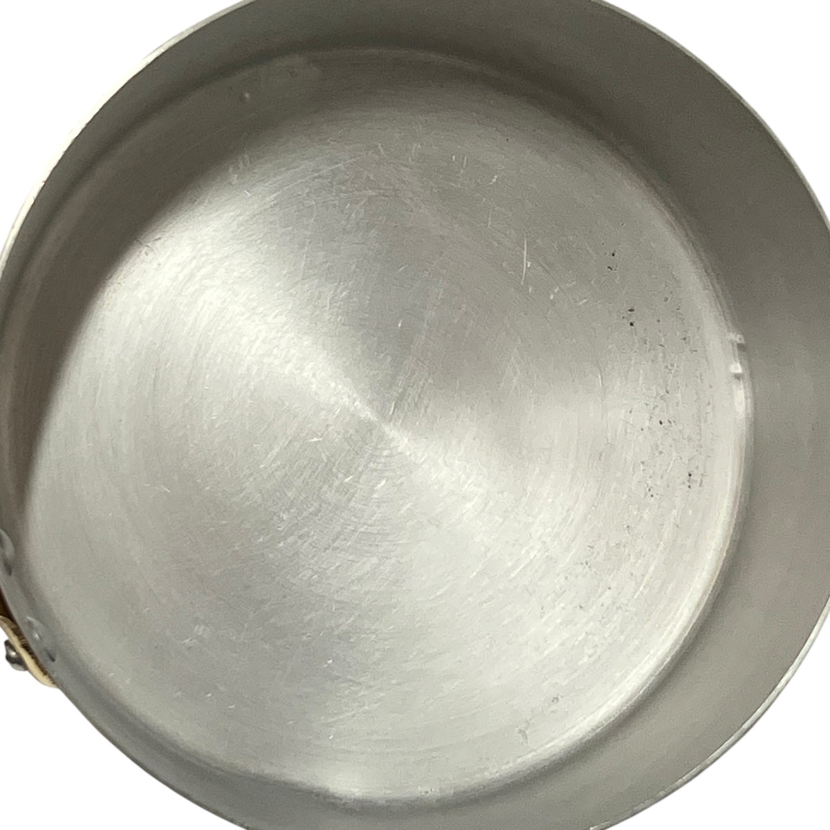 Top-down view of a brushed aluminium lined pot or pan interior on a white background.