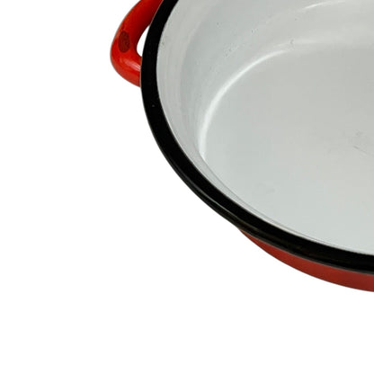 Close-up of a red enamel skillet on a white background