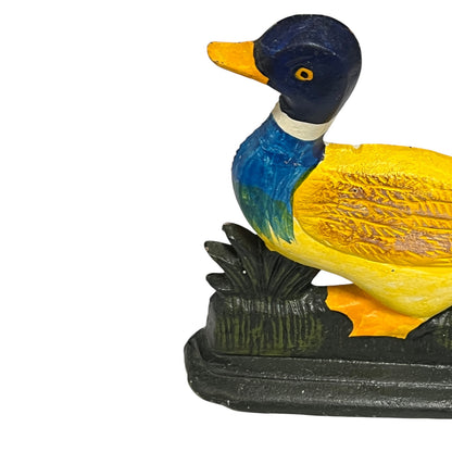 Colourful cast iron duck doorstop on a white background