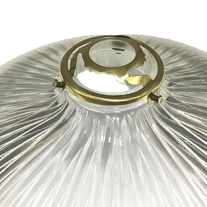 Clear glass lampshade with gold metal fitting on a white background