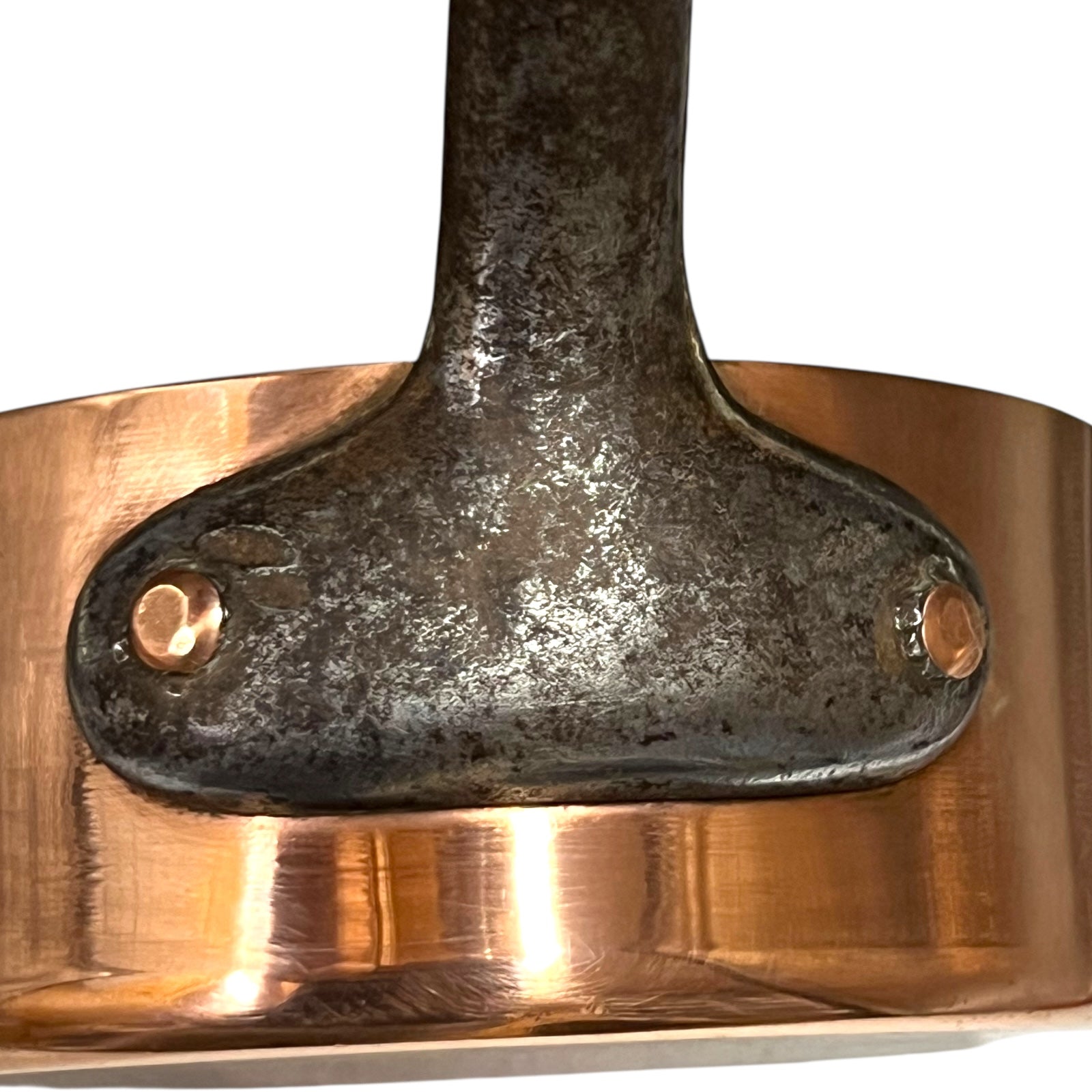 cast iron handle and copper rivets on a French copper pan