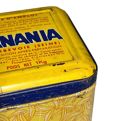 Vintage tin with 'NANIA' branding on a yellow and blue background
