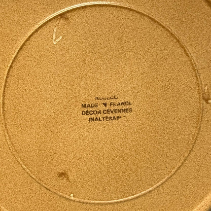 Close-up of a plate with a clear makers stamp in black text